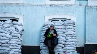 Alltag in Kiew: Vor mit Sandsäcken geschützten Fenstern verkauft eine Frau Spielzeug. Die Ukraine verteidigt sich nun seit 796 Tagen gegen den russischen Angriffskrieg. (Foto: Francisco Seco/AP/dpa)
