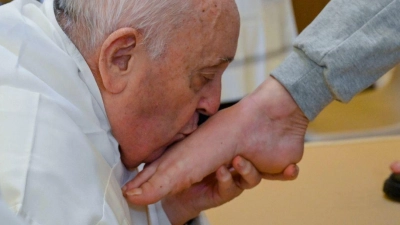 Papst Franziskus küsst den Fuß von einer weiblichen Insassin des Rebibbia-Gefängnisses. (Foto: Vatican Media/AP/dpa)