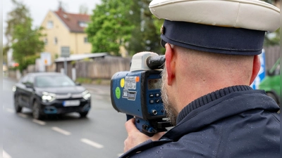 Ein Polizeibeamter nimmt in Nürnberg einen Verkehrsteilnehmer mit einem Messgerät ins Visier. (Foto: Pia Bayer/dpa)