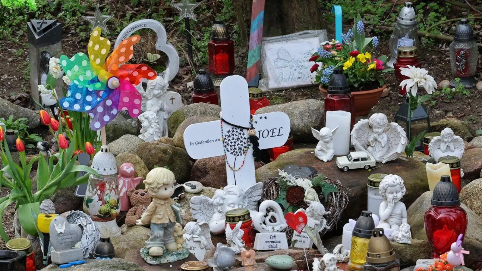 Kreuze, Figuren, Kerzen und Blumen stehen in Pragsdorf an der Stelle, wo die Leiche des kleinen Joel gefunden wurde. (Foto: Bernd Wüstneck/dpa)